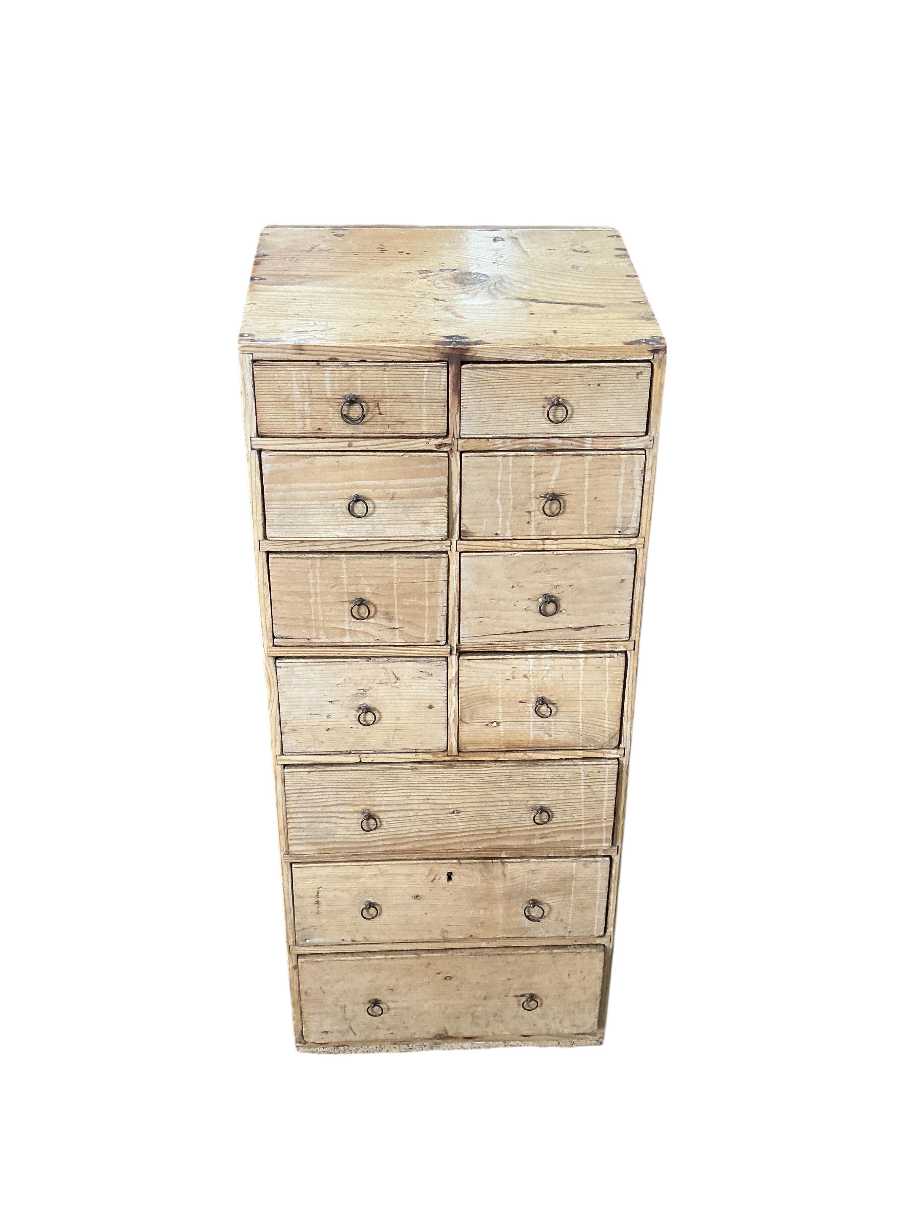 An early 19th century pine eleven drawer campaign chest with slant top, width 33cm, depth 26cm, height 80cm